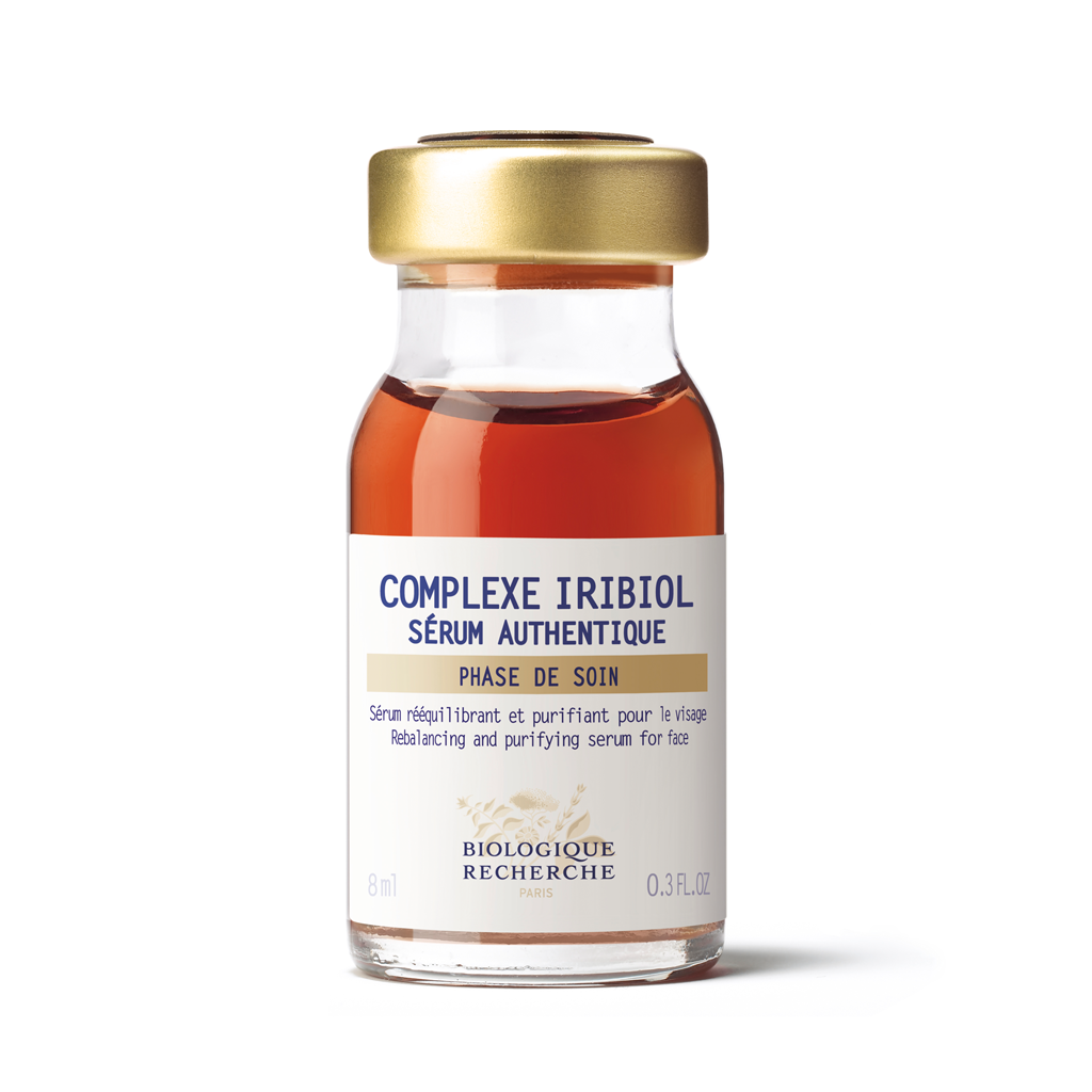 Glass bottle with gold cap and white label on a white background